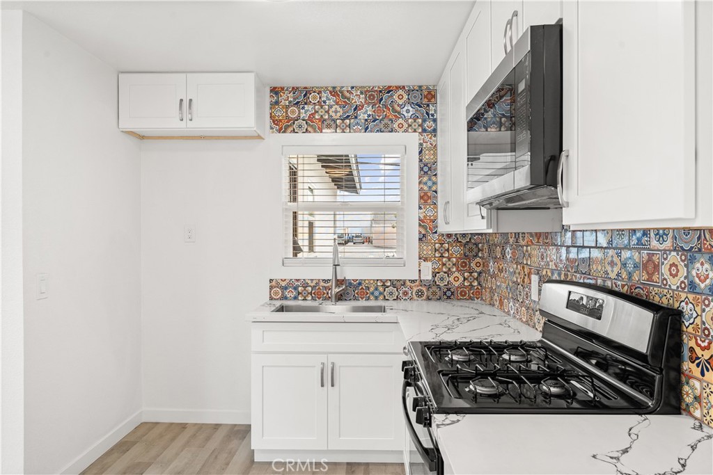 2234 South Standard Avenue Santa Ana, CA 92707 - Photo 9 of 30 a kitchen with a stove and a white cabinet
