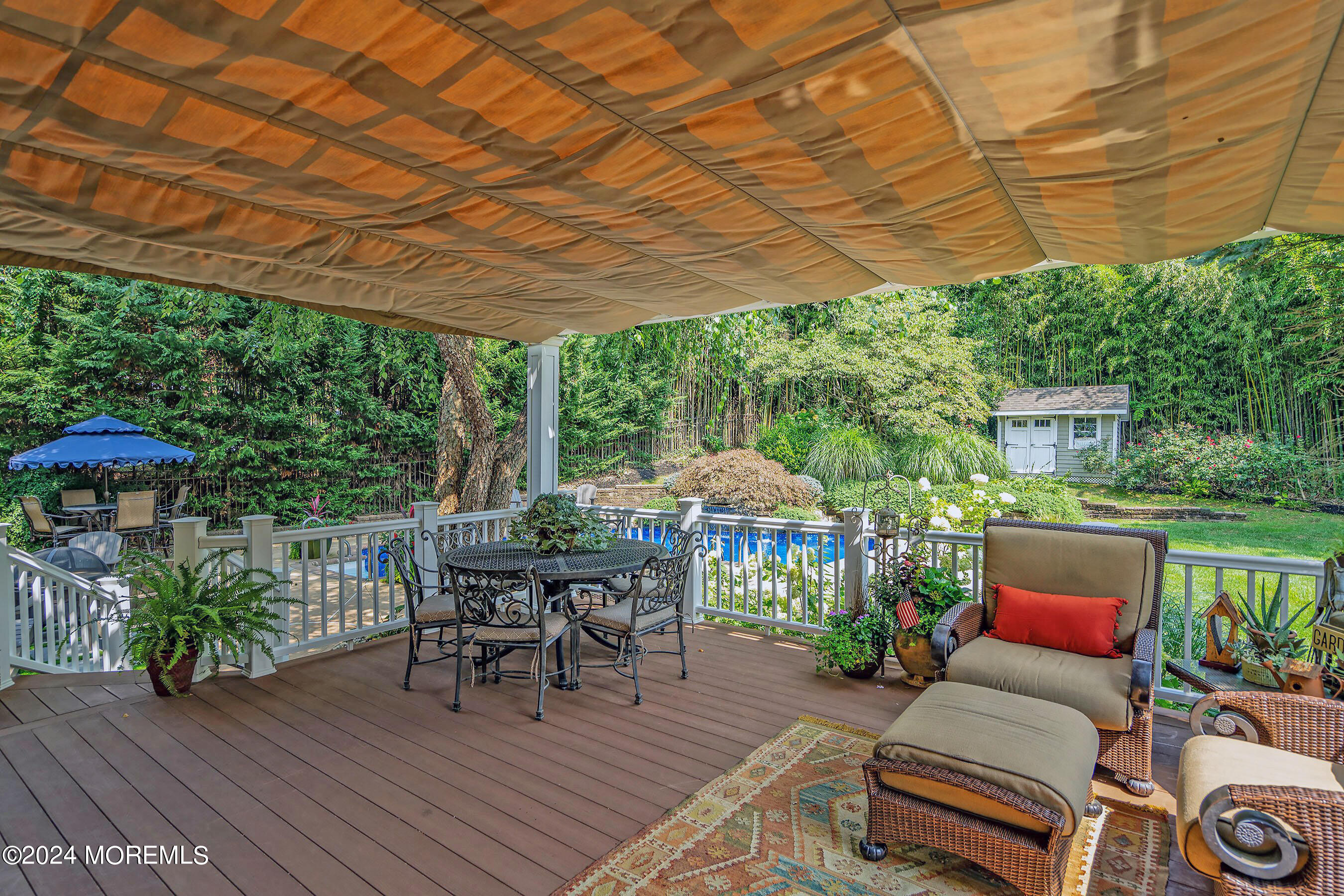 15 Doherty Drive Middletown, NJ 07748 - Photo 4 of 55 a patio with patio a table and chairs under an umbrella with a barbeque grill and wooden floor