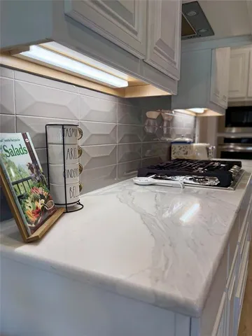 a kitchen with stainless steel appliances a sink a stove a microwave a refrigerator a counter top space and cabinets