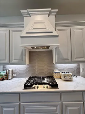 a kitchen with granite countertop a stove microwave and refrigerator