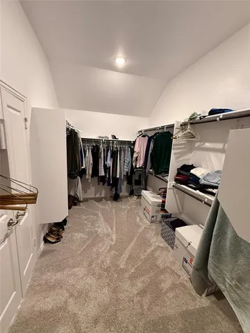 a spacious bedroom with a bed couch and window