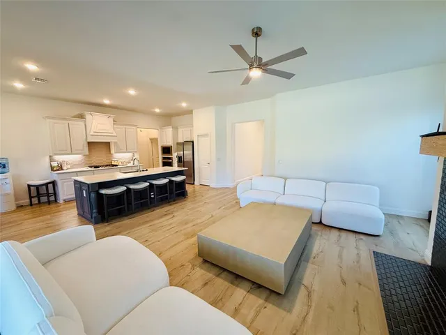 a living room with furniture and kitchen view