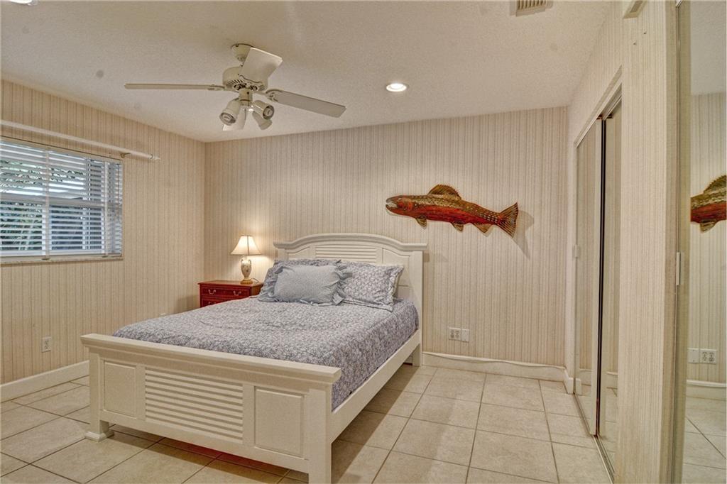 11 North River Road Stuart, FL 34996 - Photo 18 of 31 a bedroom with a bed and a chandelier