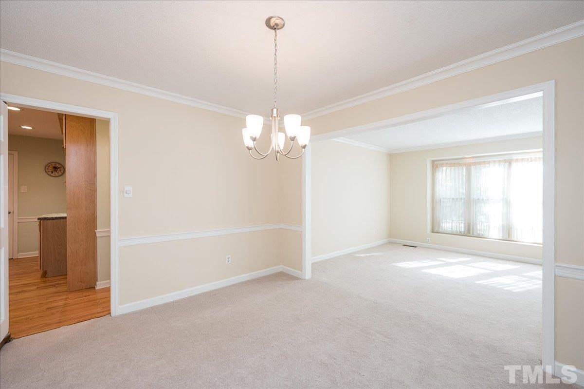 104 Dabney Road Cary, NC 27511 - Photo 11 of 35 an empty room with chandelier fan and windows