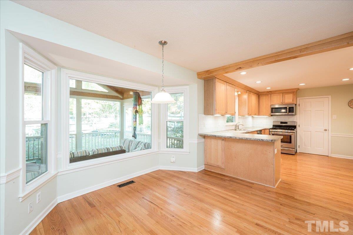 104 Dabney Road Cary, NC 27511 - Photo 17 of 35 a large kitchen with kitchen island wooden floors and stainless steel appliances