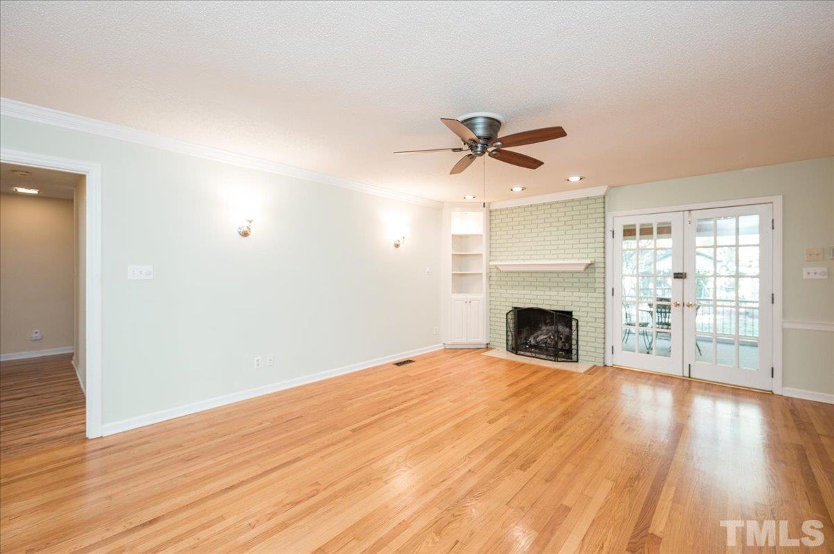 104 Dabney Road Cary, NC 27511 - Photo 18 of 35 a view of a livingroom with a fireplace a ceiling fan and wooden floor