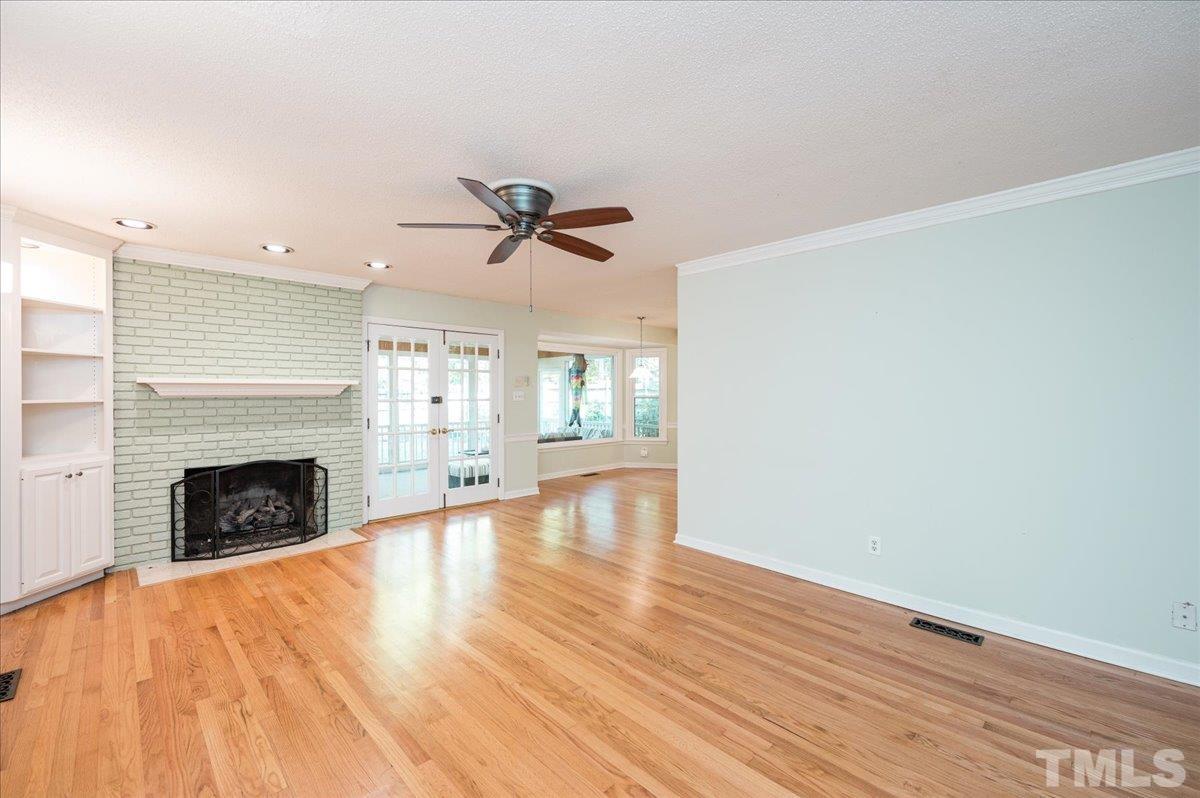 104 Dabney Road Cary, NC 27511 - Photo 21 of 35 a view of an empty room with wooden floor fireplace and a window