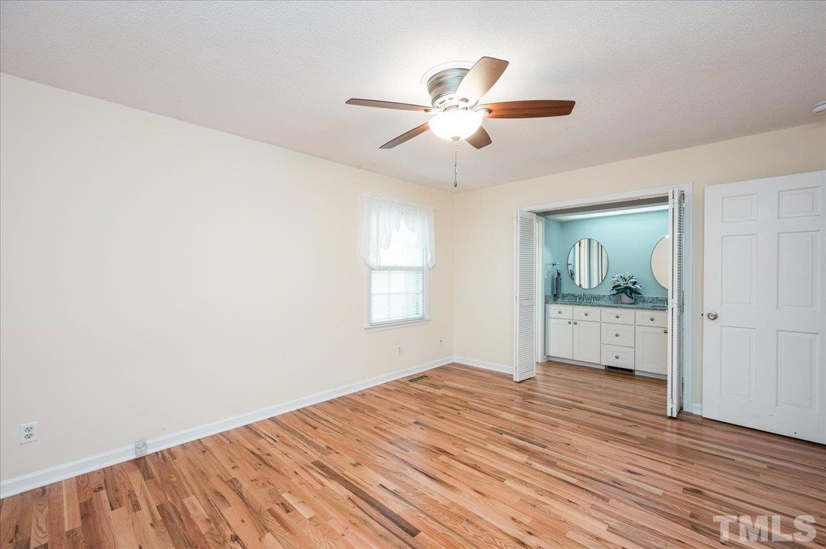 104 Dabney Road Cary, NC 27511 - Photo 23 of 35 a bedroom with a bed and a chandelier