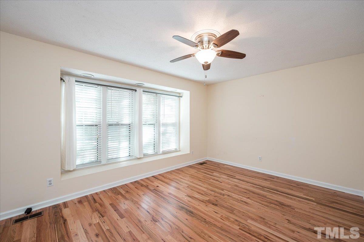 104 Dabney Road Cary, NC 27511 - Photo 28 of 35 a view of an empty room with wooden floor and a window
