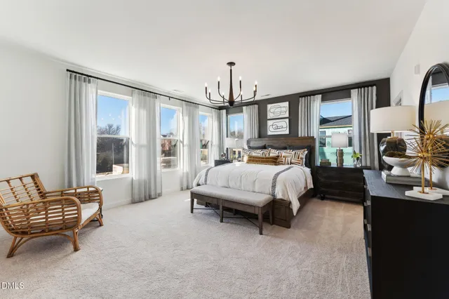 a spacious bedroom with a bed a couch and dresser