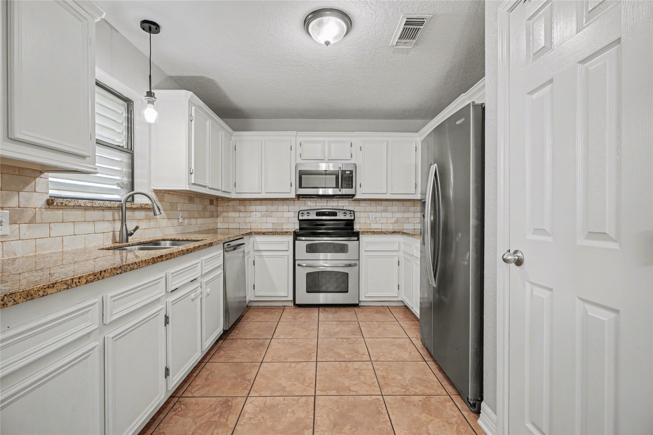 12431 9th Street Santa Fe, TX 77510 - Photo 5 of 18 a kitchen with a sink cabinets and appliances