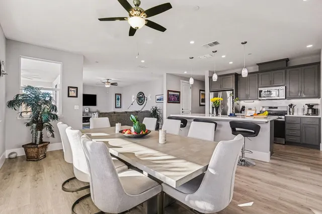a kitchen with stainless steel appliances granite countertop a sink cabinets and wooden floor