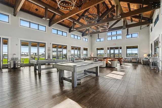 a living room with furniture a wooden floor and next to a large window