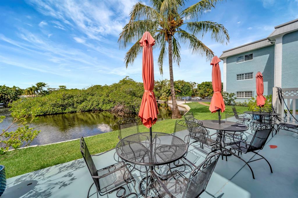 3000 Northeast 5th Terrace, Unit 109A Wilton Manors, FL 33334 - Photo 17 of 36 a view of a chairs and table in patio with a lake view