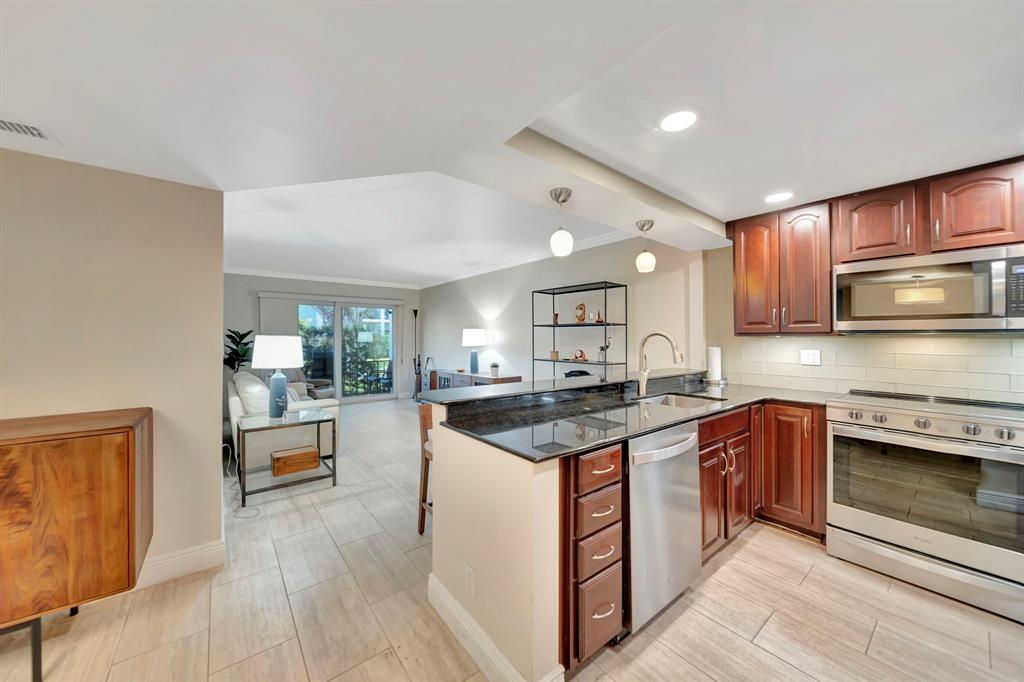 3000 Northeast 5th Terrace, Unit 109A Wilton Manors, FL 33334 - Photo 22 of 36 a kitchen with stainless steel appliances granite countertop a stove and a sink