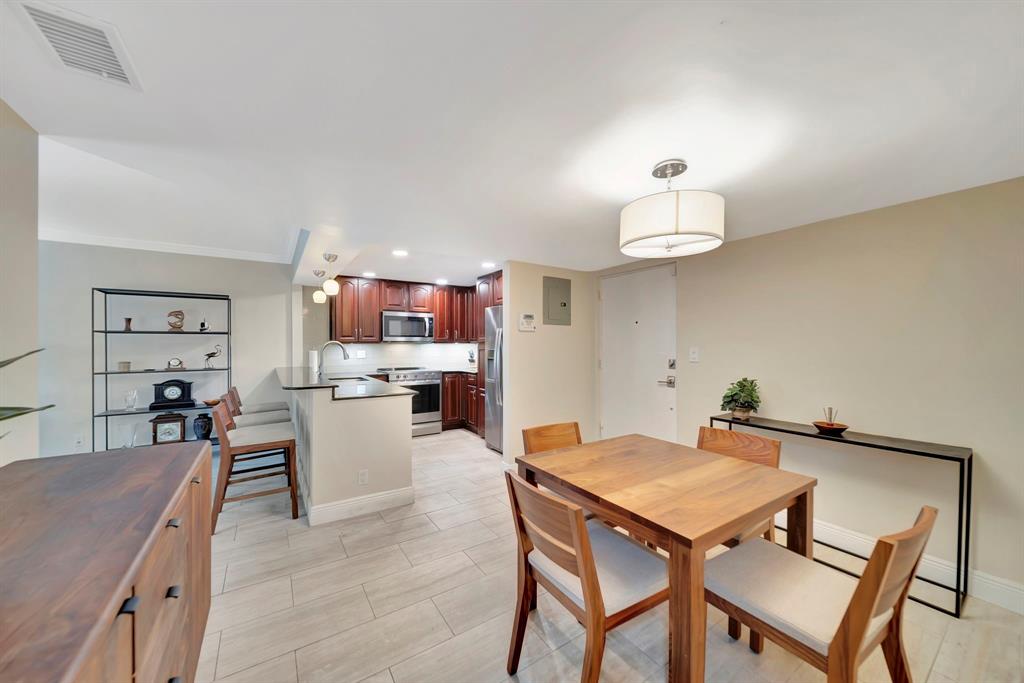 3000 Northeast 5th Terrace, Unit 109A Wilton Manors, FL 33334 - Photo 23 of 36 a view of a dining room with furniture and wooden floor