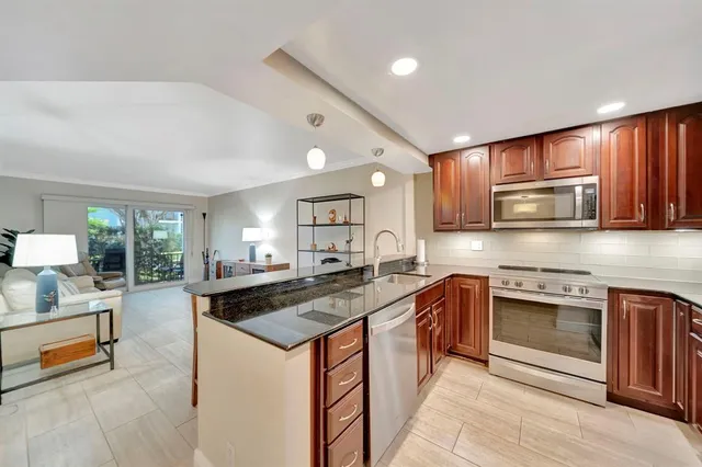a kitchen with stainless steel appliances granite countertop a sink stove and cabinets