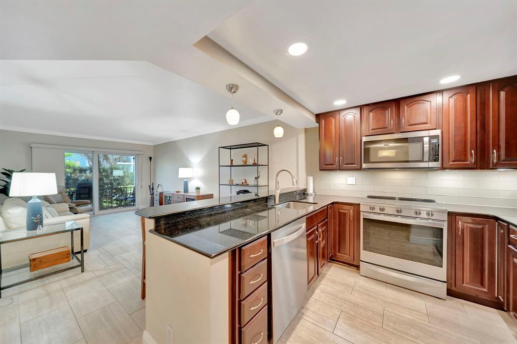 3000 Northeast 5th Terrace, Unit 109A Wilton Manors, FL 33334 - Photo 3 of 36 a kitchen with stainless steel appliances granite countertop a sink stove and cabinets