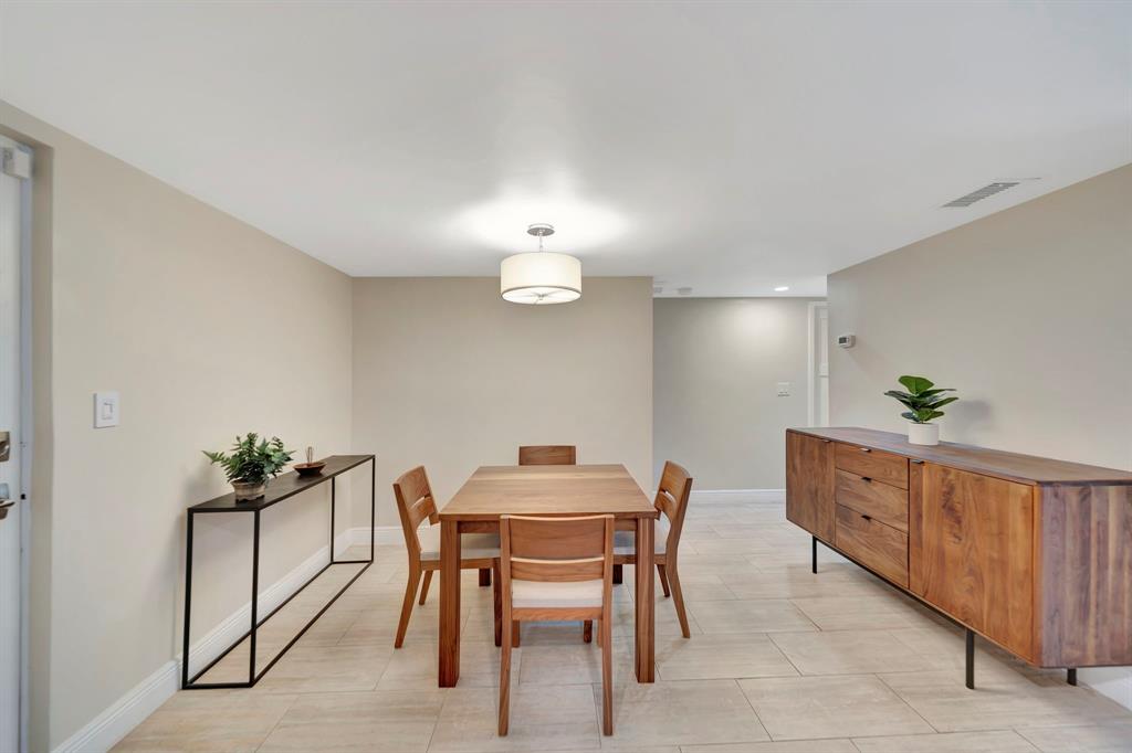 3000 Northeast 5th Terrace, Unit 109A Wilton Manors, FL 33334 - Photo 5 of 36 a dining room with furniture and wooden floor