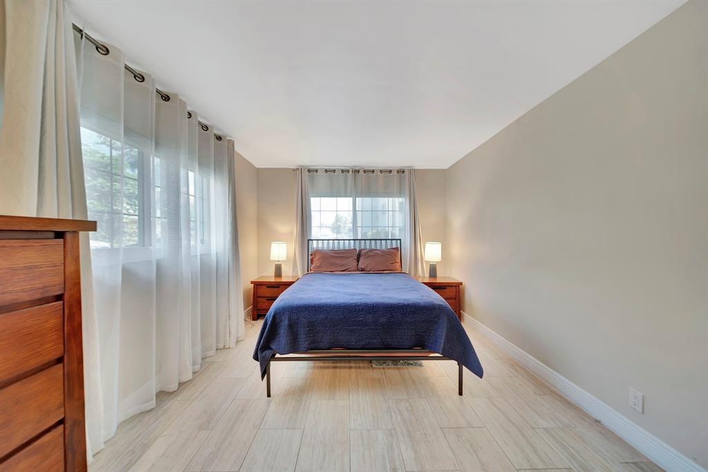 3000 Northeast 5th Terrace, Unit 109A Wilton Manors, FL 33334 - Photo 9 of 36 a hallway with a large window and wooden floor