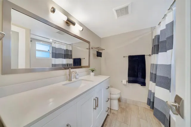 a spacious bathroom with a double vanity sink toilet and shower