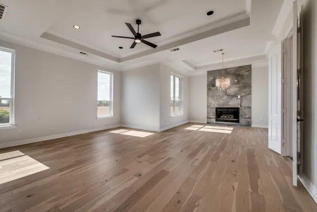 a view of empty room with wooden floor and fireplace