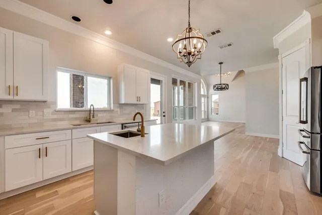 a kitchen with stainless steel appliances granite countertop a sink a stove and a refrigerator