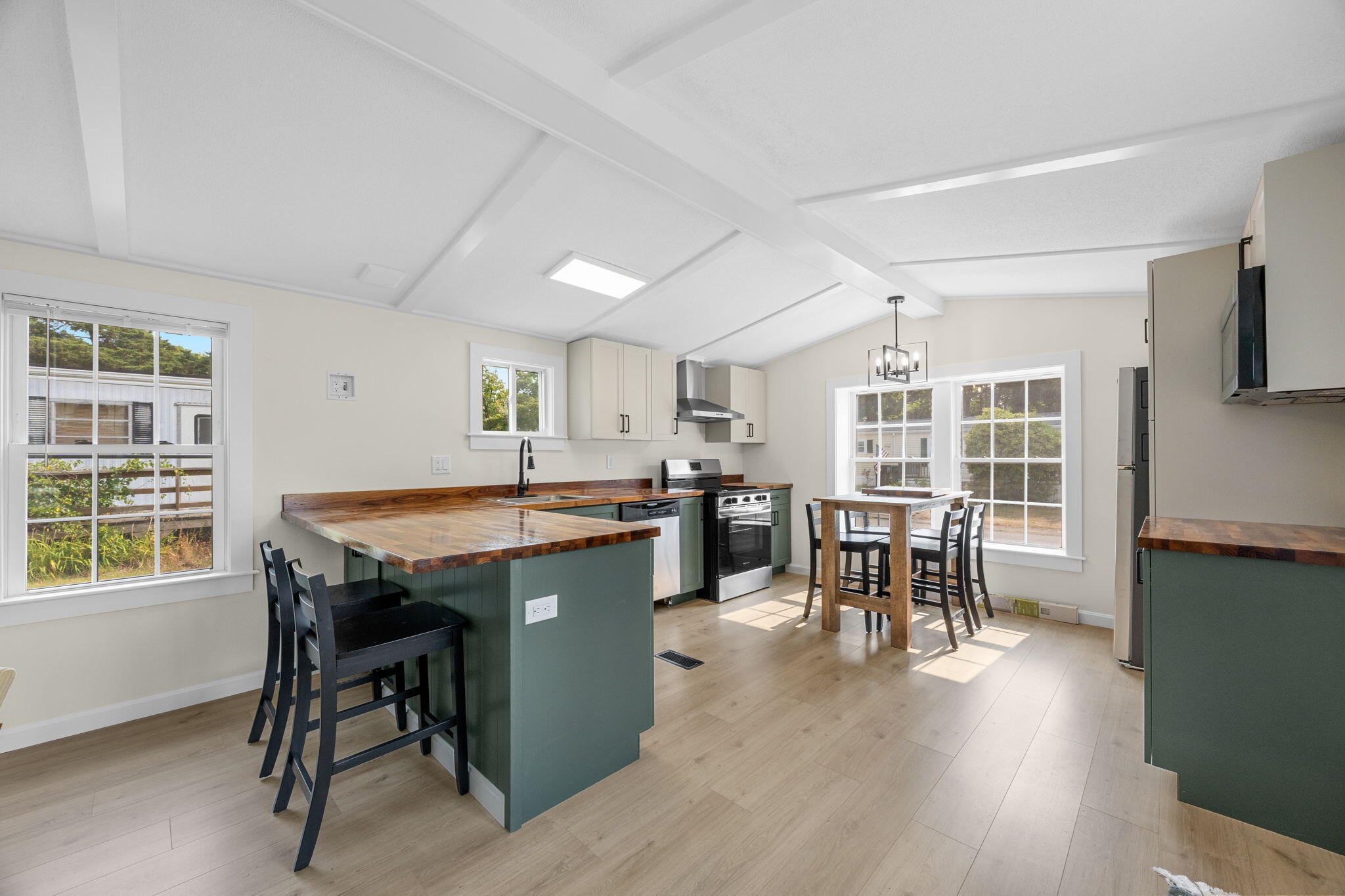 15 1st Street Bourne, MA 02559 - Photo 15 of 30 a dining hall with stainless steel appliances granite countertop a stove a table and chairs with wooden floor