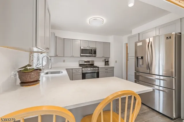 a kitchen with stainless steel appliances granite countertop a refrigerator stove and sink