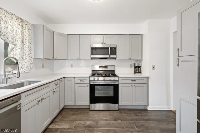 a kitchen with cabinets stainless steel appliances and a sink