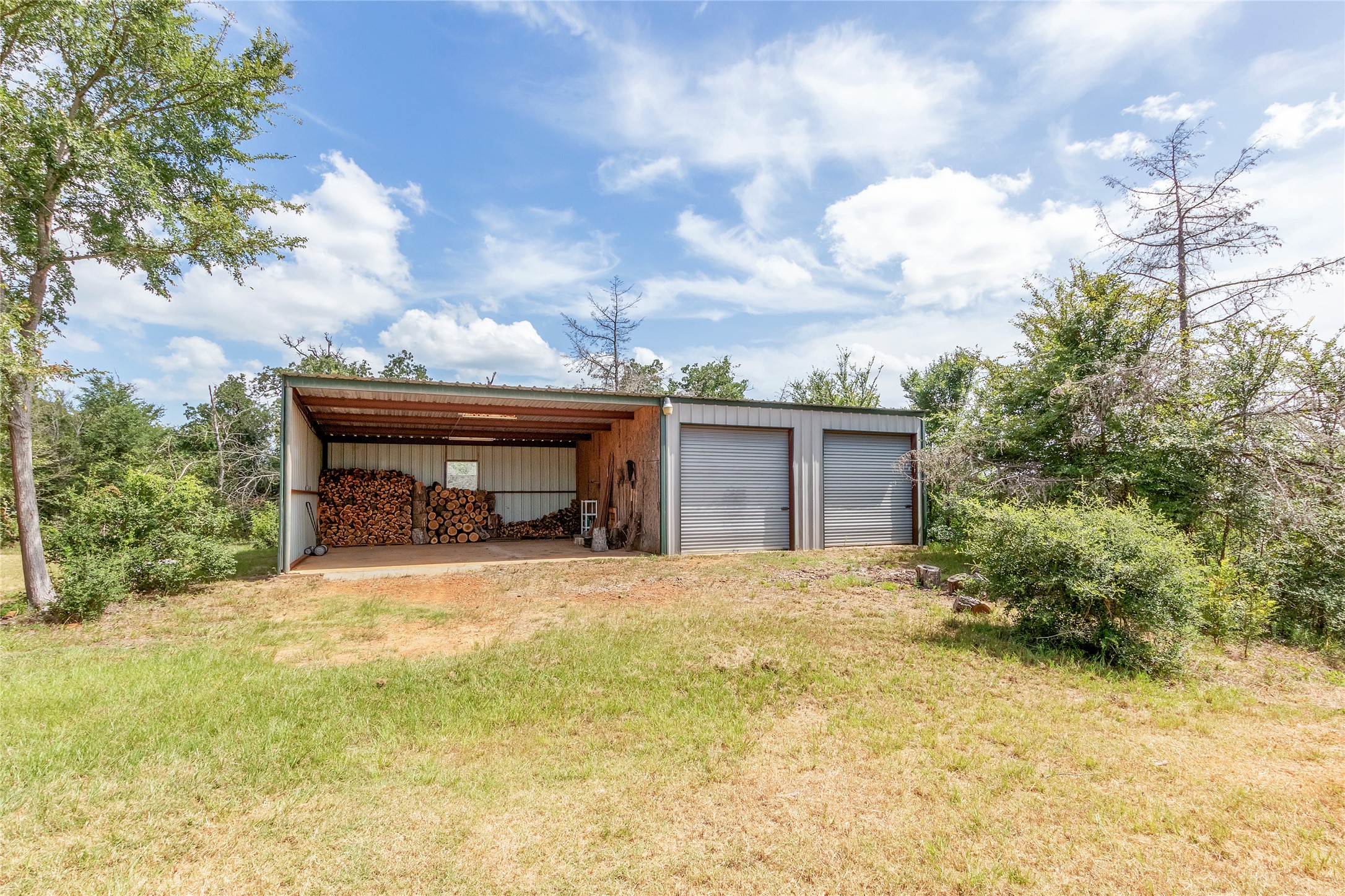 1004 22 Hills Road Gause, TX 77857 - Photo 37 of 37 A versatile metal outbuilding offers both covered storage and a two-door garage for diverse needs.