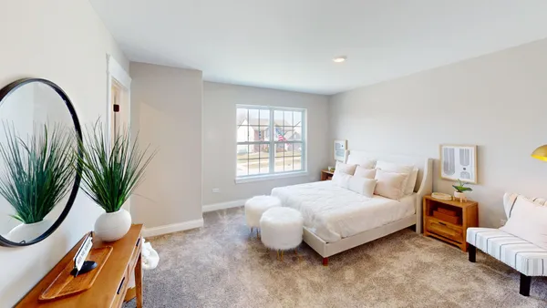 a bedroom with bed and a potted plant