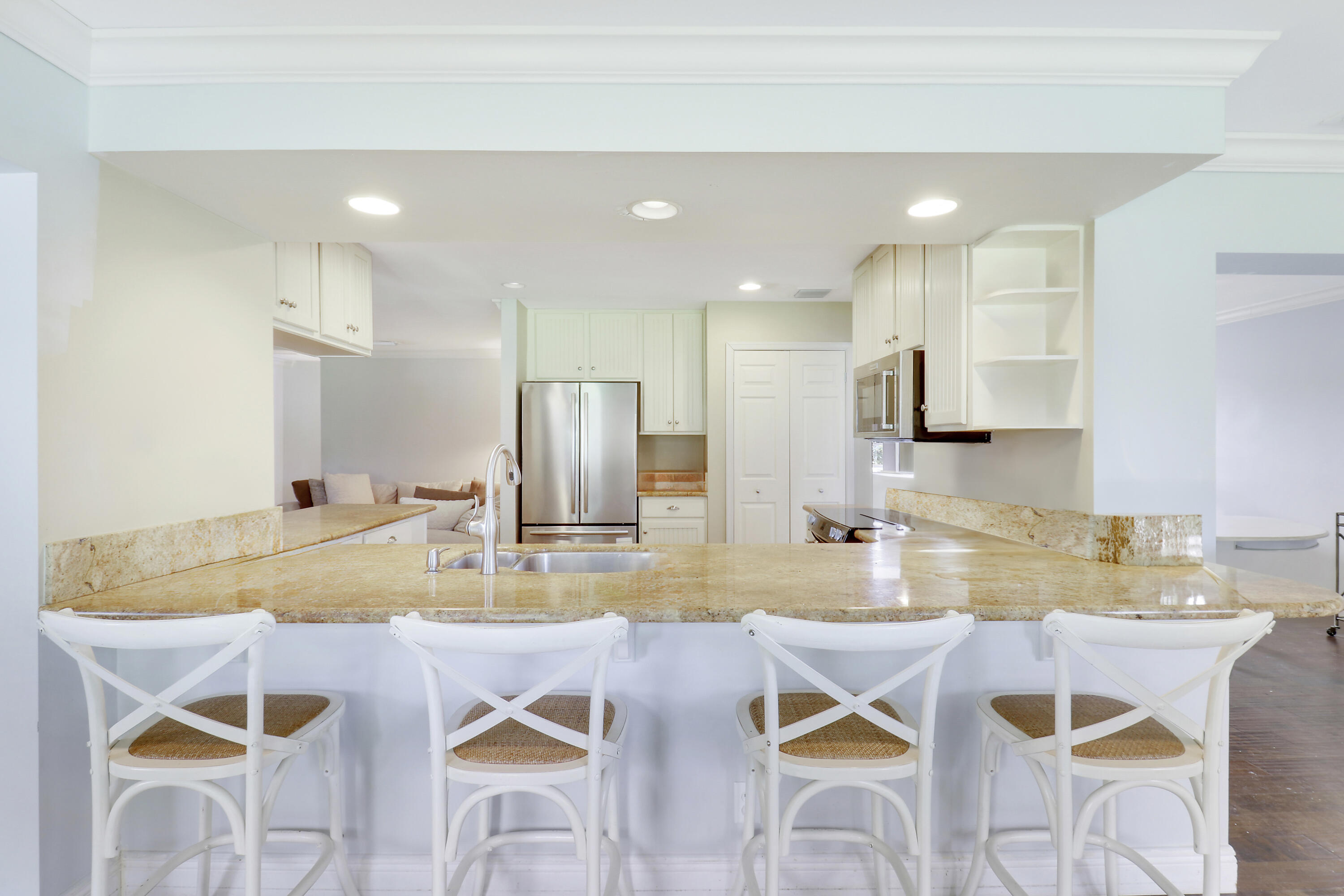 749 Cruiser Road North North Palm Beach, FL 33408 - Photo 11 of 46 a kitchen with a dining table chairs and white cabinets