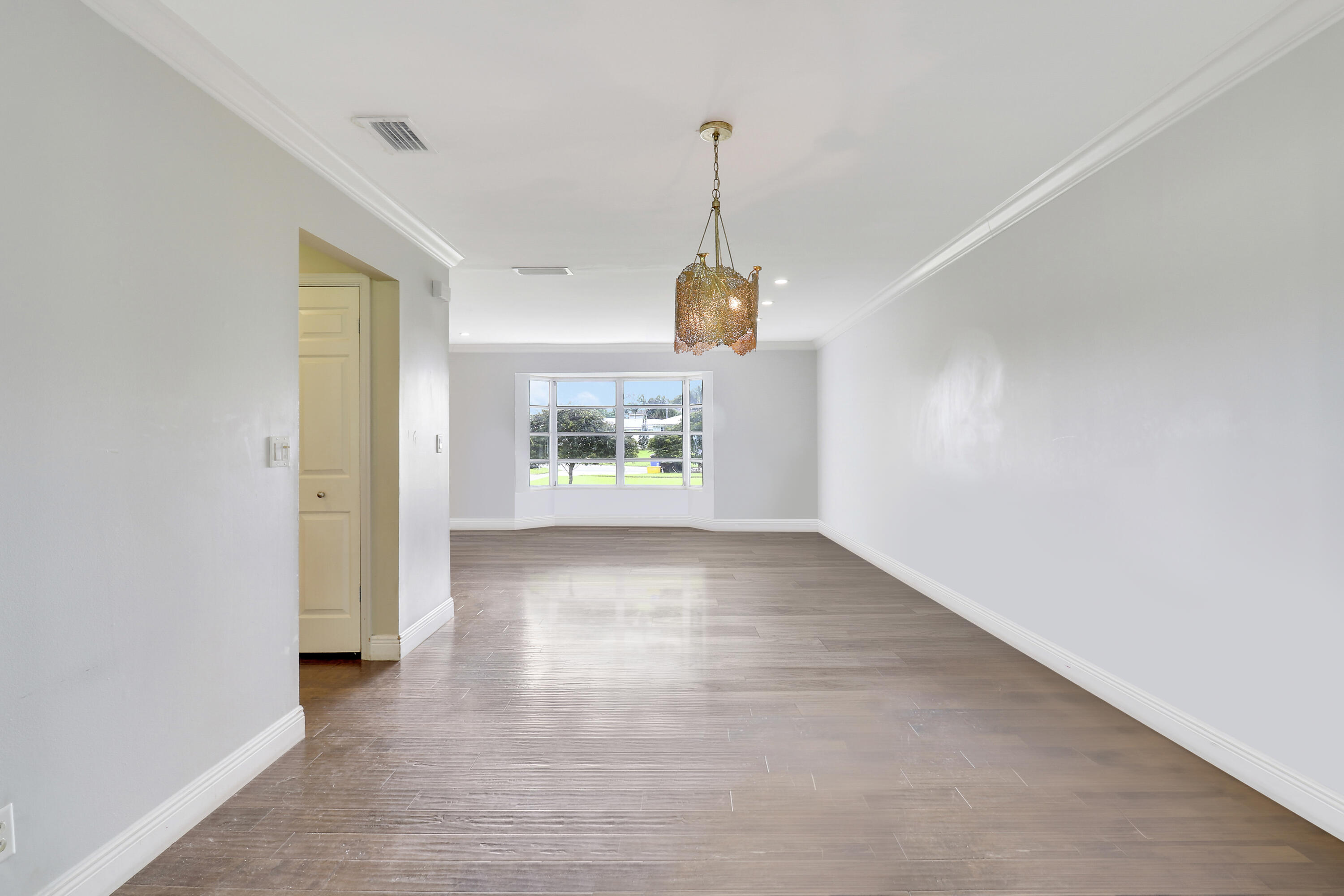 749 Cruiser Road North North Palm Beach, FL 33408 - Photo 17 of 46 a view of an empty room with window and wooden floor