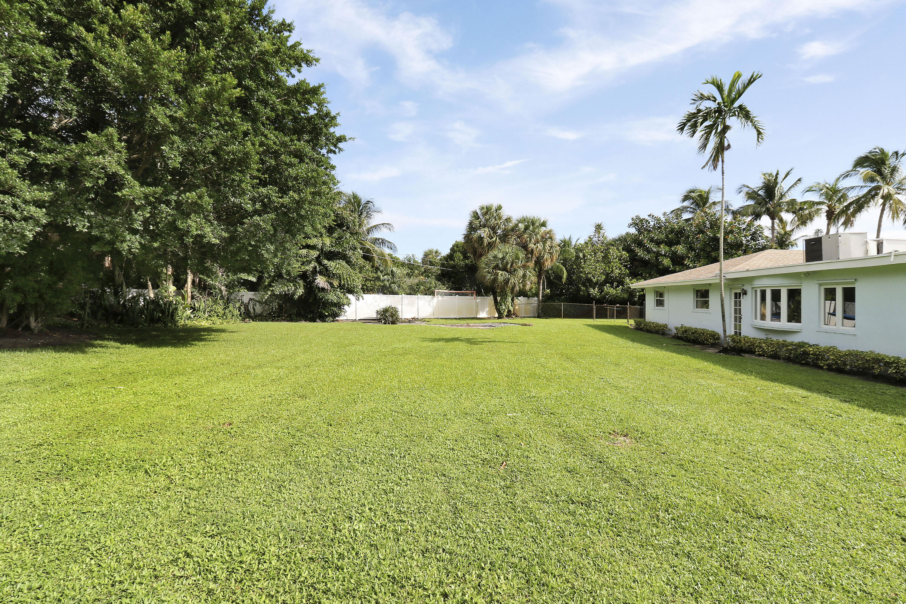749 Cruiser Road North North Palm Beach, FL 33408 - Photo 27 of 46 a front view of a house with a garden and trees