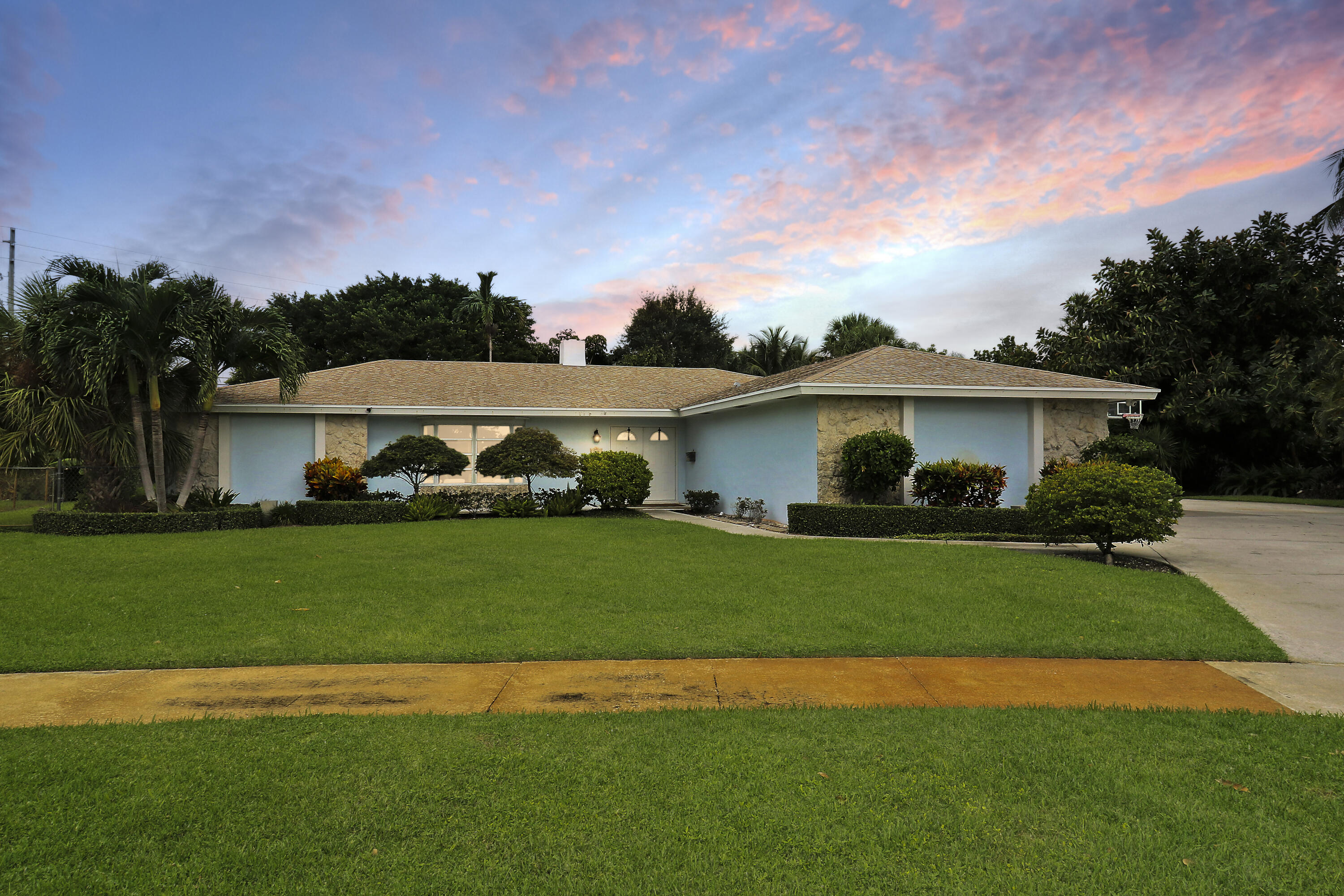 749 Cruiser Road North North Palm Beach, FL 33408 - Photo 3 of 46 a front view of a house with a garden