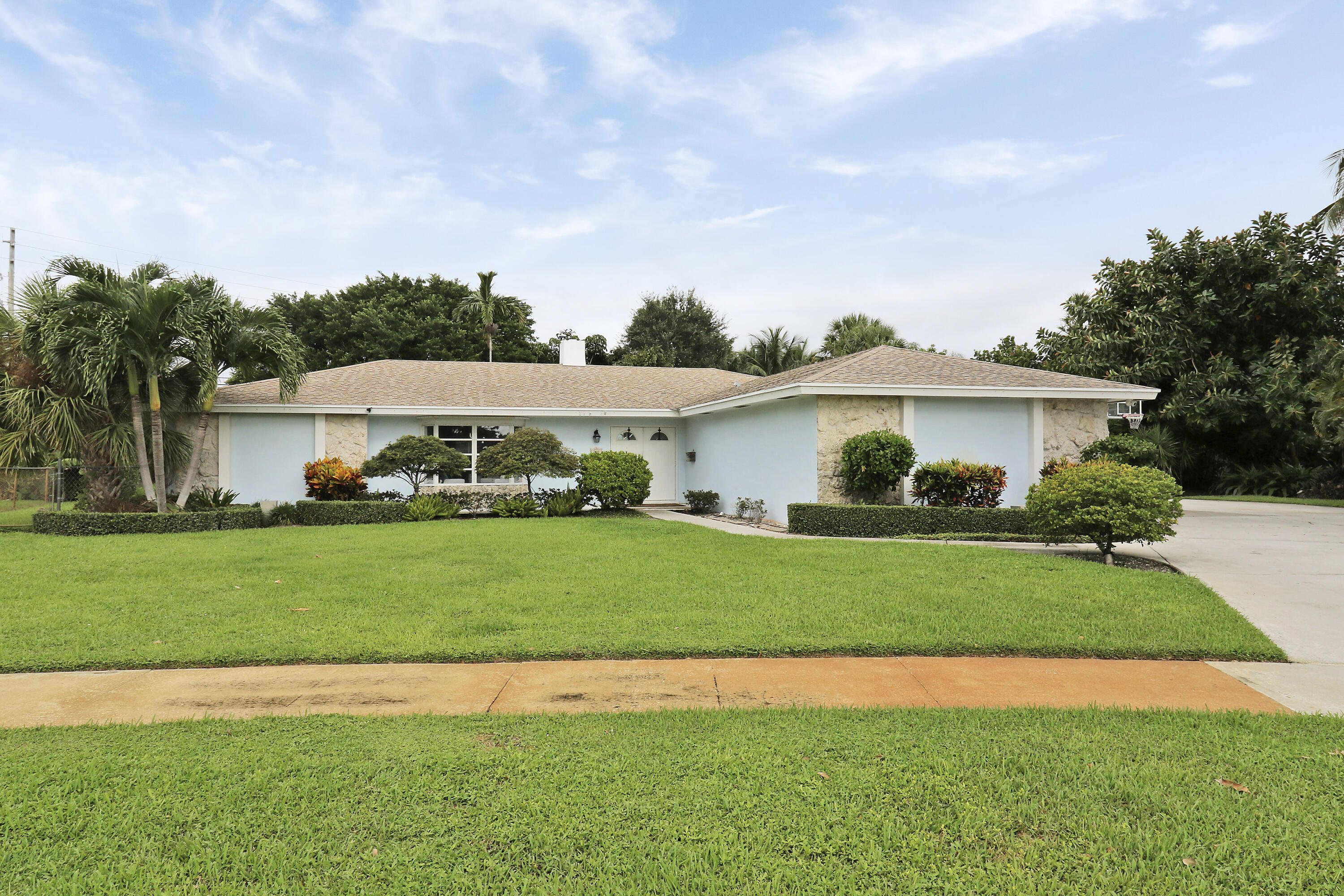 749 Cruiser Road North North Palm Beach, FL 33408 - Photo 4 of 46 a front view of a house with a yard and garage