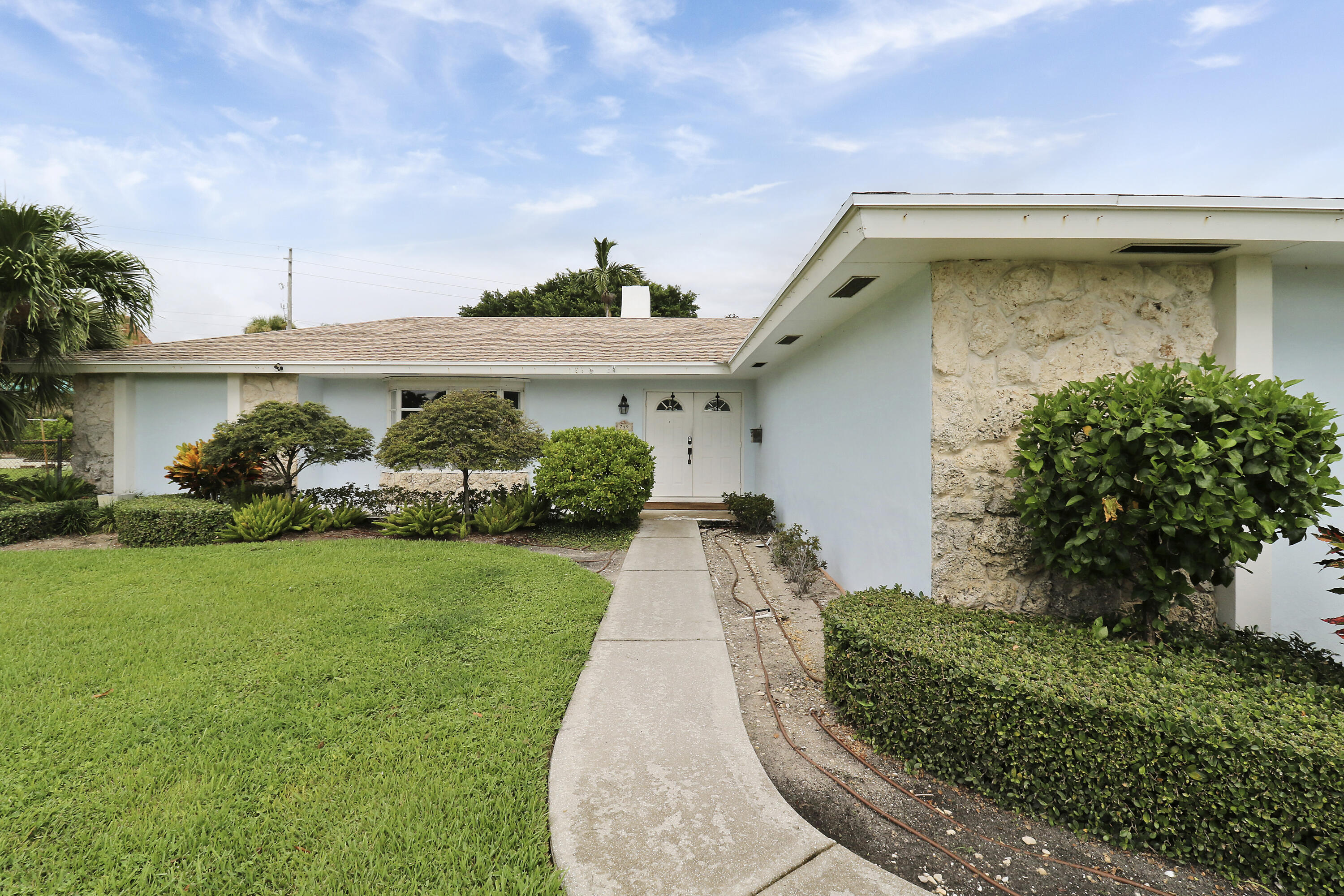 749 Cruiser Road North North Palm Beach, FL 33408 - Photo 6 of 46 a front view of a house with garden