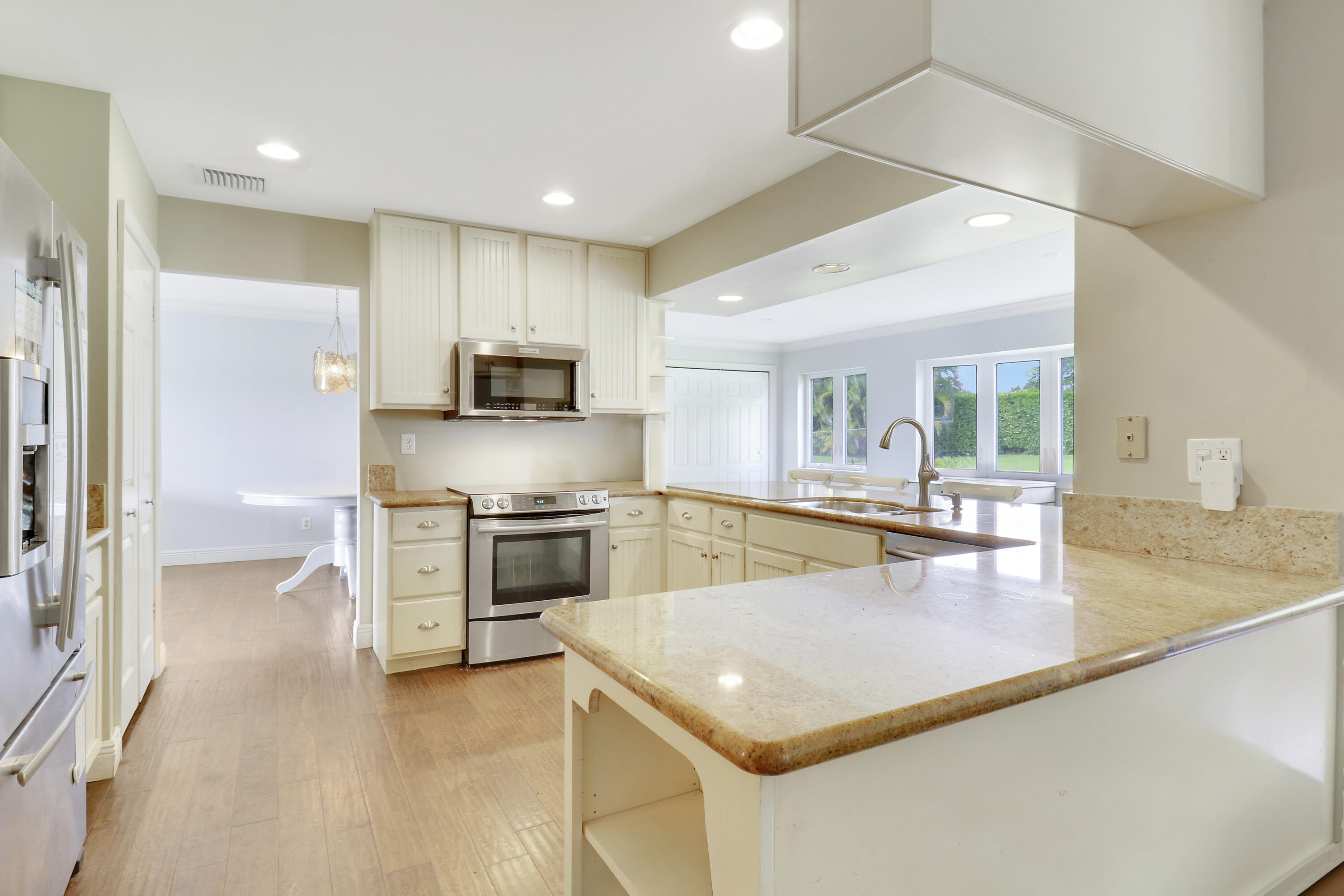 749 Cruiser Road North North Palm Beach, FL 33408 - Photo 9 of 46 a kitchen with stainless steel appliances granite countertop a sink a stove and a refrigerator