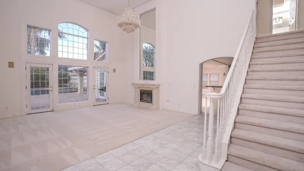 a view of an empty room with stairs and a window