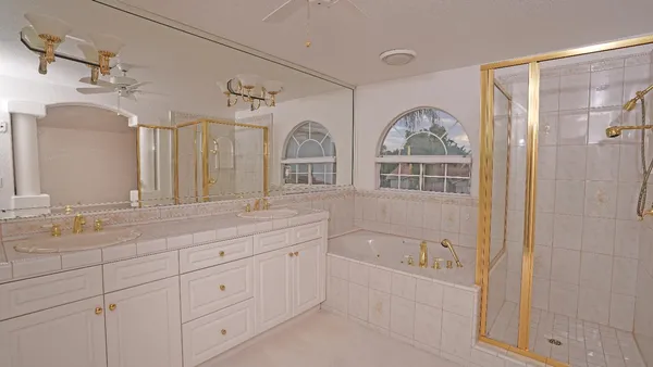 a spacious bathroom with double vanity a mirror a double vanity sinks and a shower