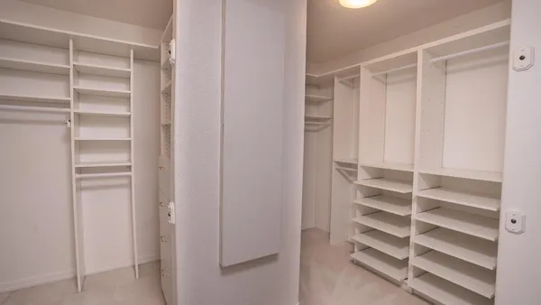 a view of walk in closet with empty racks