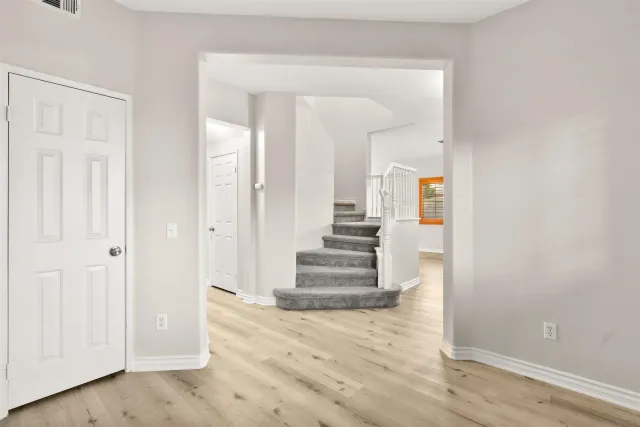 a view of a hallway with wooden floor and entryway