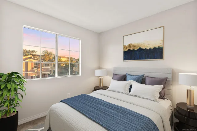 a bedroom with a bed and a painting on the wall