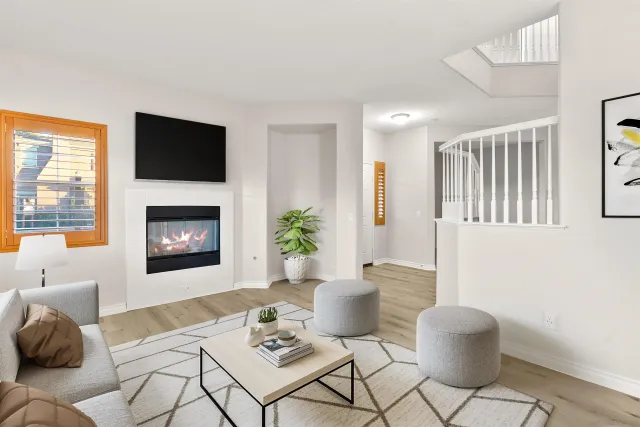 a living room with furniture a flat screen tv and a fireplace