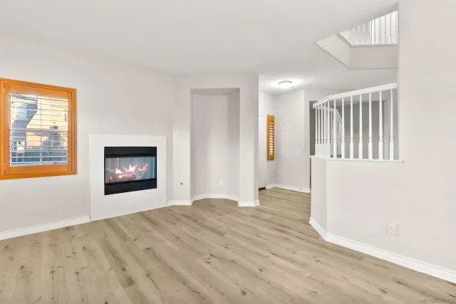 a view of an empty room with a window and fireplace