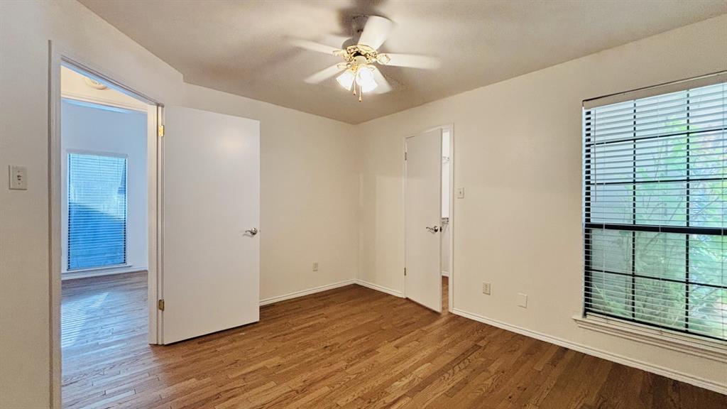 4019 Rive Lane Addison, TX 75001 - Photo 12 of 37 Second bedroom with walk-in closet, wood floors, ceiling fan and overhead light.