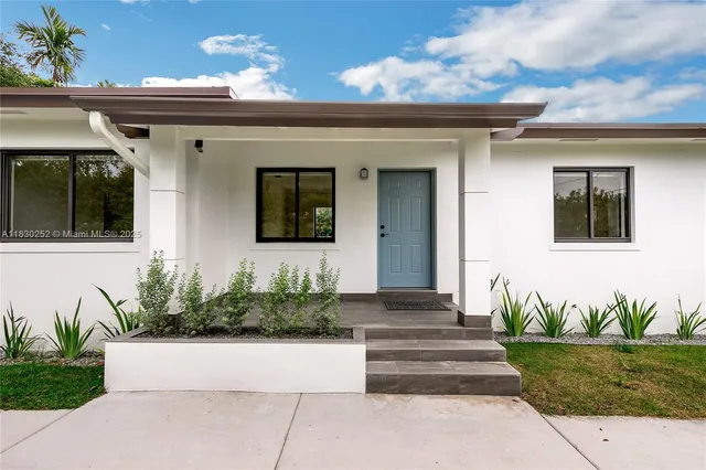 a front view of a house with potted plants