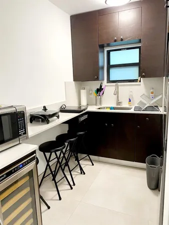 a kitchen with a sink and chairs