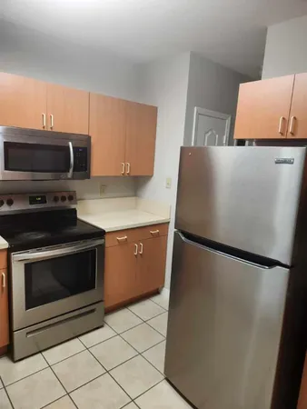 a kitchen with stainless steel appliances a refrigerator sink and microwave